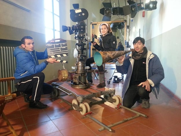 Lee Min Ho on the set of a drama, interacting with the director and crew. The scene shows a complex setup with multiple cameras and lighting equipment, highlighting the scale of the production.
