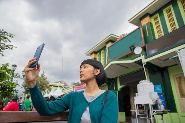 A US fan using a smartphone with a navigation app to find a dorama filming location in a bustling South Korean street, showcasing independent exploration.