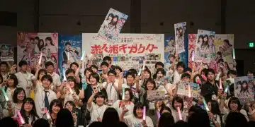 Dorama fans enthusiastically participating in a fan project at a convention, holding banners and lightsticks.