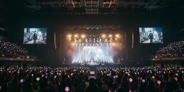 Enthusiastic K-Drama fans with lightsticks at a U.S. fan meeting, anticipating an actor's appearance