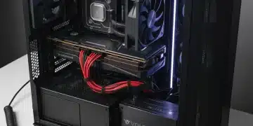 Technician installing a new power supply unit in a high-performance gaming PC case, showing organized internal components.